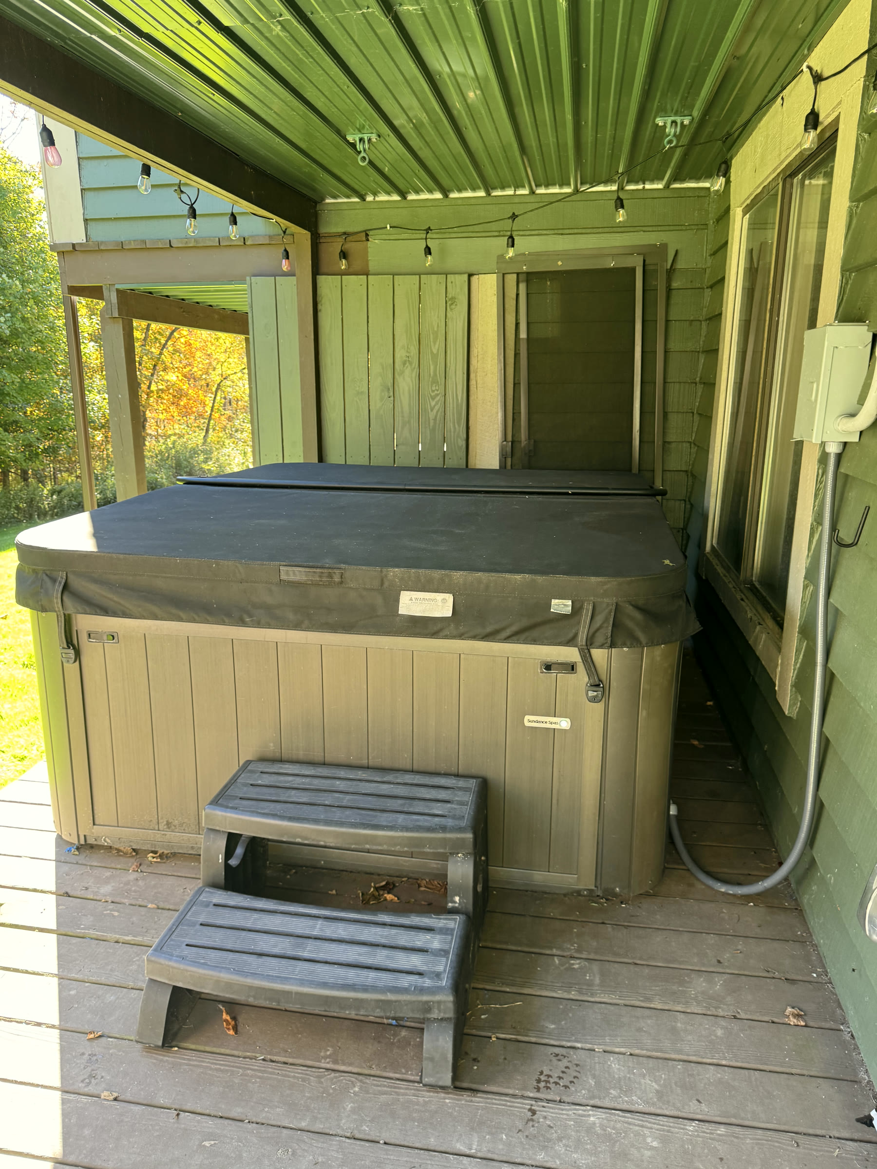 Kooser's hot tub porch in daylight, with yellow leaves outside